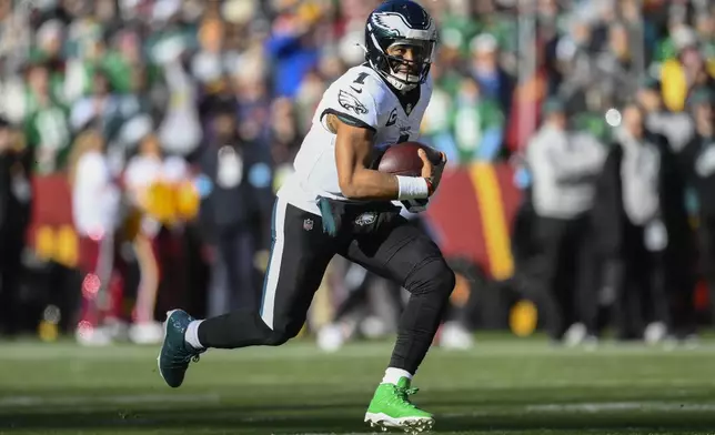 Philadelphia Eagles quarterback Jalen Hurts (1) running with the ball during the first half of an NFL football game against the Washington Commanders, Sunday, Dec. 22, 2024, in Landover, Md. (AP Photo/Nick Wass)