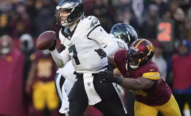 Philadelphia Eagles quarterback Kenny Pickett (7) avoids a tackle by Washington Commanders linebacker Bobby Wagner (54) during the second half of an NFL football game, Sunday, Dec. 22, 2024, in Landover, Md. (AP Photo/Stephanie Scarbrough)