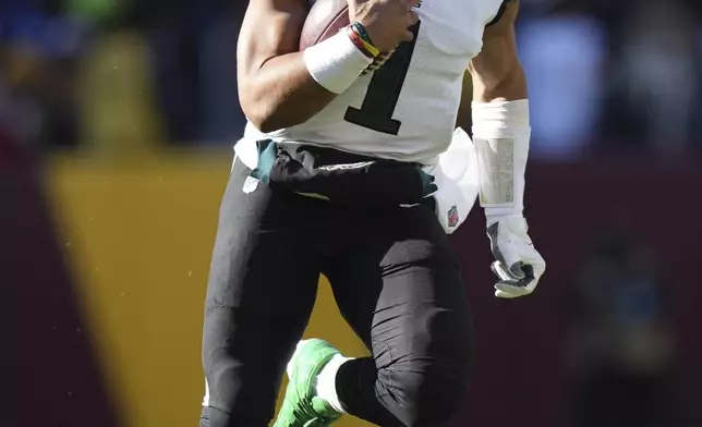 Philadelphia Eagles quarterback Jalen Hurts (1) running with the ball during the first half of an NFL football game against the Washington Commanders, Sunday, Dec. 22, 2024, in Landover, Md. (AP Photo/Stephanie Scarbrough)