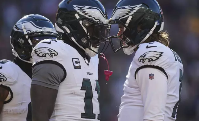 Philadelphia Eagles wide receiver A.J. Brown (11) celebrating his touchdown with teammate quarterback Kenny Pickett (7) during the first half of an NFL football game, Sunday, Dec. 22, 2024, in Landover, Md. (AP Photo/Stephanie Scarbrough)