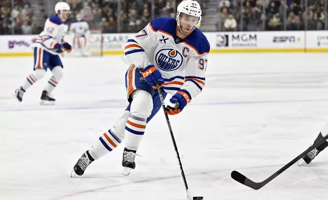 Edmonton Oilers center Connor McDavid (97) skates with the puck against the Vegas Golden Knights during the first period of an NHL hockey game Tuesday, Dec. 3, 2024, in Las Vegas. (AP Photo/David Becker)