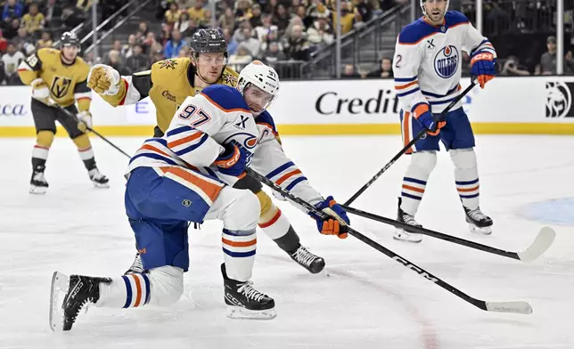 Vegas Golden Knights center Jack Eichel and Edmonton Oilers center Connor McDavid (97) vie for the puck during the second period of an NHL hockey game, Tuesday, Dec. 3, 2024, in Las Vegas. (AP Photo/David Becker)