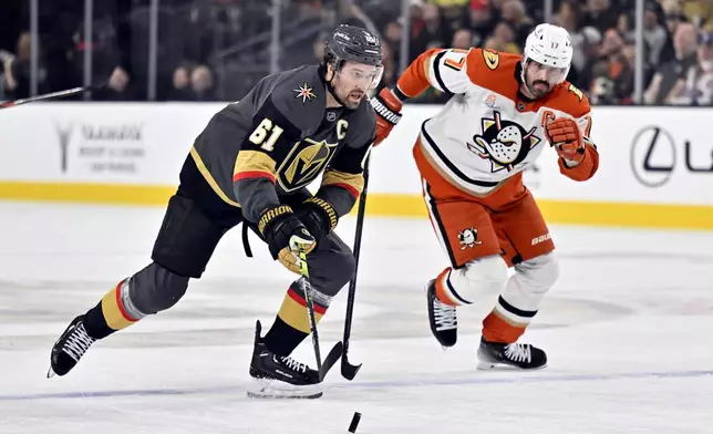 Vegas Golden Knights right wing Mark Stone (61) skates with the puck against Anaheim Ducks left wing Alex Killorn (17) during the first period of an NHL hockey game Monday, Dec. 23, 2024, in Las Vegas. (AP Photo/David Becker)