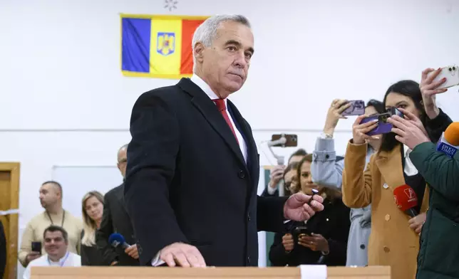 Calin Georgescu, an independent candidate for president who came first after the first round of presidential elections, casts his vote in the country's parliamentary elections, in Mogosoaia, Romania, Sunday, Dec. 1, 2024. (AP Photo/Alexandru Dobre)