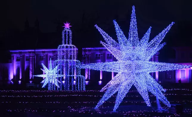 The pleasure garden and the water palace are illuminated at the opening of the "Christmas Garden" light show in the grounds of Pillnitz Palace, Dresden, Germany, Thursday Nov. 21, 2024. (Robert Michael/dpa via AP)