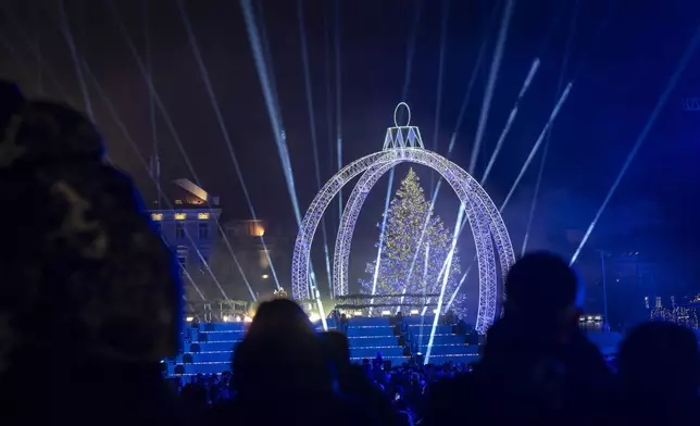 The National Christmas tree is lit during the lighting ceremony at Cathedral square in Vilnius, Lithuania, Friday, Nov. 29, 2024. (AP Photo/Mindaugas Kulbis)
