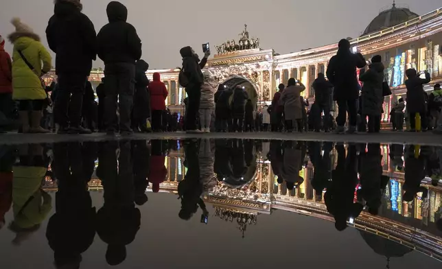 People watch a light show at the Palace Square in St. Petersburg, Russia, Sunday, Dec. 8, 2024. (AP Photo/Dmitri Lovetsky)