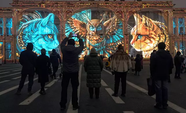People watch a light show at the Palace Square in St. Petersburg, Russia, Sunday, Dec. 8, 2024. (AP Photo/Dmitri Lovetsky)