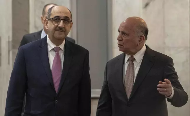 Syrian Foreign Minister Bassam Sabbagh, left, is welcomed by his Iraqi counterpart Fouad Hussein during his visit to Baghdad, Iraq, Friday, Dec. 6, 2024. (AP Photo/Hadi Mizban)
