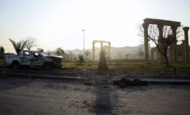 The body of a government soldier lies on the ground next to a damaged car in the aftermath of opposition fighters' takeover in Hama, Syria, on Friday, Dec. 6, 2024. (AP Photo/Omar Albam)
