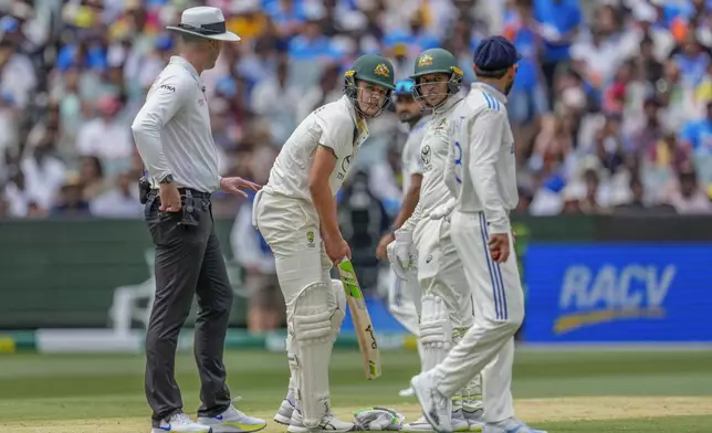 India's Virat Kohli, right, talks to Australia's Sam Konstas, second left, as Australia's Usman Khawaja, looks on during play on the first day of the fourth cricket test between Australia and India at the Melbourne Cricket Ground, Melbourne, Australia, Thursday, Dec. 26, 2024. (AP Photo/Asanka Brendon Ratnayake)