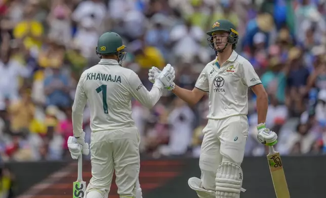 Australia's Sam Konstas, right, celebrates scoring fifty runs with his batting partner Usman Khawaja during play on the first day of the fourth cricket test between Australia and India at the Melbourne Cricket Ground, Melbourne, Australia, Thursday, Dec. 26, 2024. (AP Photo/Asanka Brendon Ratnayake)