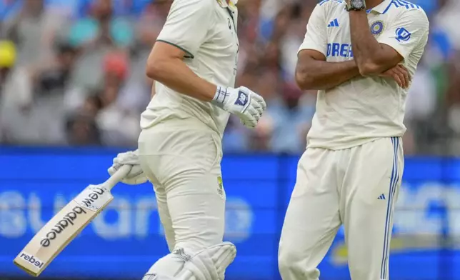 India's Akash Deep, right, reacts after being hit for a boundary by Australia's captain Pat Cummins, left, during play on the first day of the fourth cricket test between Australia and India at the Melbourne Cricket Ground, Melbourne, Australia, Thursday, Dec. 26, 2024. (AP Photo/Asanka Brendon Ratnayake)