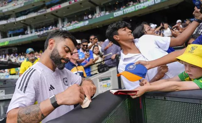 India's Virat Kohli signs his autograph ahead of play on the first day of the fourth cricket test between Australia and India at the Melbourne Cricket Ground, Melbourne, Australia, Thursday, Dec. 26, 2024. (AP Photo/Asanka Brendon Ratnayake)