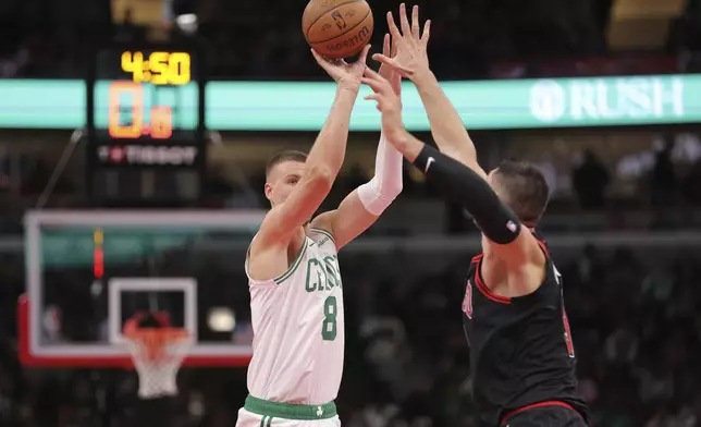 Boston Celtics center Kristaps Porzingis (8) shoots a 3-point basket over Chicago Bulls center Nikola Vucevic, right, during the second half of an Emirates NBA Cup basketball game, Friday Nov. 29, 2024, in Chicago. (AP Photo/Melissa Tamez)