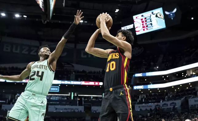 Atlanta Hawks forward Zaccharie Risacher (10) looks to shoot a 3-point basket over Charlotte Hornets forward Brandon Miller (24) during the second half of an NBA basketball game, Saturday, Nov. 30, 2024, in Charlotte, N.C. (AP Photo/Matt Kelley)