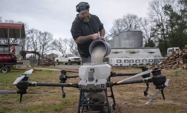 Russell Hedrick prepares a DJI drone to put crop cover on his farm, Tuesday, Dec. 17, 2024, in Hickory, N.C. (AP Photo/Allison Joyce)