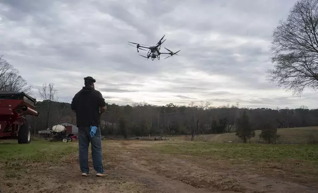 Russell Hedrick uses a DJI drone to put crop cover on his farm, Tuesday, Dec. 17, 2024, in Hickory, N.C. (AP Photo/Allison Joyce)