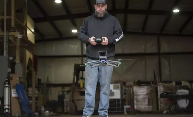 Russell Hedrick flies a drone on his farm, Tuesday, Dec. 17, 2024, in Hickory, N.C. (AP Photo/Allison Joyce)