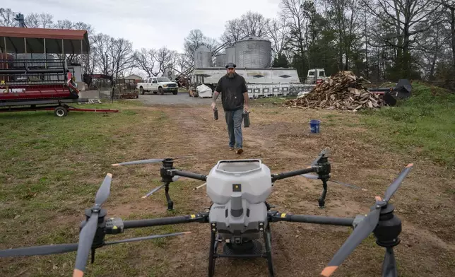 Russell Hedrick prepares a DJI drone to put crop cover on his farm, Tuesday, Dec. 17, 2024, in Hickory, N.C. (AP Photo/Allison Joyce)