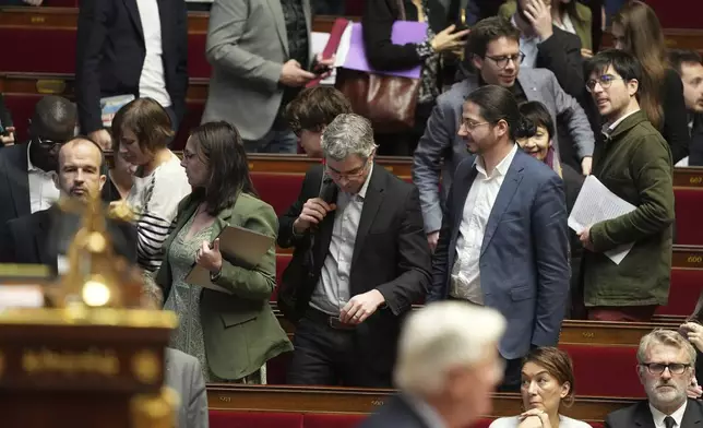 Leftist parliament members leave as French Prime Minister Michel Barnier delivers his speech at the National Assembly while France's minority government may be on its last legs as opposition lawmakers moved this week toward a no-confidence vote, Monday, Dec. 2, 2024 in Paris. (AP Photo/Michel Euler)