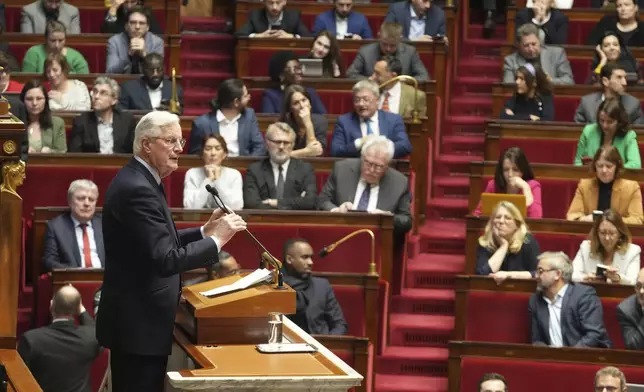 French Prime Minister Michel Barnier delivers his speech at the National Assembly while France's minority government may be on its last legs as opposition lawmakers moved this week toward a no-confidence vote, Monday, Dec. 2, 2024 in Paris. (AP Photo/Michel Euler)