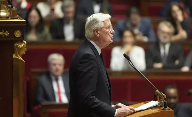 French Prime Minister Michel Barnier delivers his speech at the National Assembly while France's minority government may be on its last legs as opposition lawmakers moved this week toward a no-confidence vote, Monday, Dec. 2, 2024 in Paris. (AP Photo/Michel Euler)