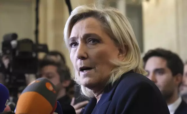 French far-right leader Marine Le Pen answers reporters at the National Assembly to confirm the National Rally party will vote against Prime Minister Michel Barnier in an upcoming no-confidence vote, Monday, Dec. 2, 2024 in Paris. (AP Photo/Michel Euler)