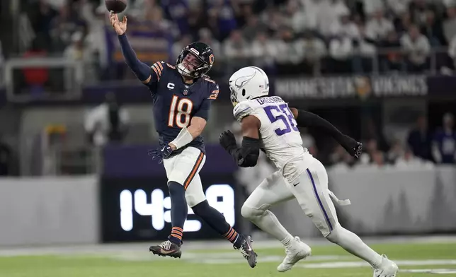 Chicago Bears quarterback Caleb Williams (18) throws a pass over Minnesota Vikings linebacker Jonathan Greenard (58) during the second half of an NFL football game, Monday, Dec. 16, 2024, in Minneapolis. (AP Photo/Abbie Parr)