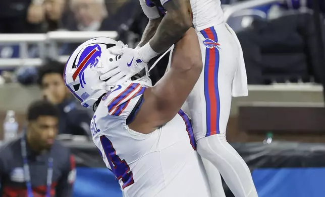 Buffalo Bills running back James Cook, top, is congratulated by guard O'Cyrus Torrence after scoring against the Detroit Lions during the second half of an NFL football game, Sunday, Dec. 15, 2024, in Detroit. (AP Photo/Duane Burleson)