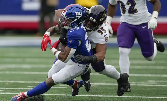 New York Giants running back Tyrone Tracy Jr. (29) is tackled by Baltimore Ravens linebacker Tavius Robinson (95) during the second quarter of an NFL football game, Sunday, Dec. 15, 2024, in East Rutherford, N.J. (AP Photo/Seth Wenig)