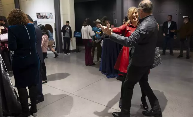 Dr. Annette Goldberg dances with Sheldon Weisfeld during a Chicanukah mariachi performance at Holocaust Museum Houston on Thursday, December 19, 2024, in Houston. (AP Photo/Annie Mulligan)