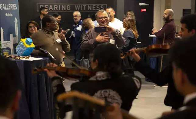 Guests enjoy a performance by Mariachi Palmeros during a Chicanukah event at Holocaust Museum Houston on Thursday, Dec. 19, 2024, in Houston. (AP Photo/Annie Mulligan)