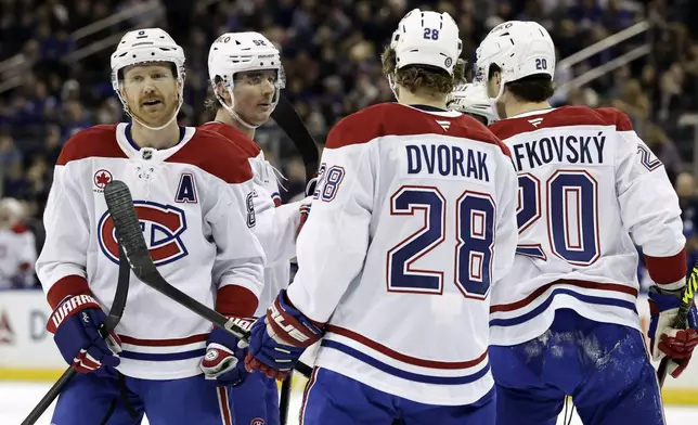 Montreal Canadiens defenseman Mike Matheson, left, is congratulated by teammates after scoring a goal in the first period of an NHL hockey game against the New York Rangers, Saturday, Nov. 30, 2024, in New York. (AP Photo/Adam Hunger)