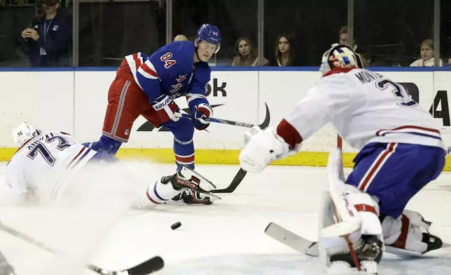 New York Rangers center Adam Edstrom (84) passes the puck around Montreal Canadiens defenseman Arber Xhekaj in the second period of an NHL hockey game Saturday, Nov. 30, 2024, in New York. (AP Photo/Adam Hunger)