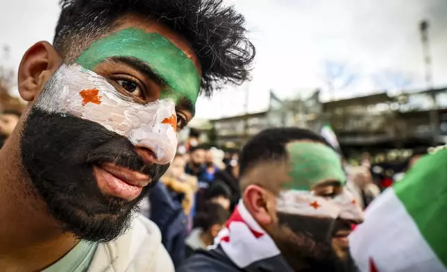 Men with their faces painted in as the Syrian opposition flag attend a rally in Wuppertal, Germany, Sunday, Dec. 8, 2024, following the fall of Syrian president Bashar Assad’s government. (Christoph Reichwein/dpa/dpa via AP)