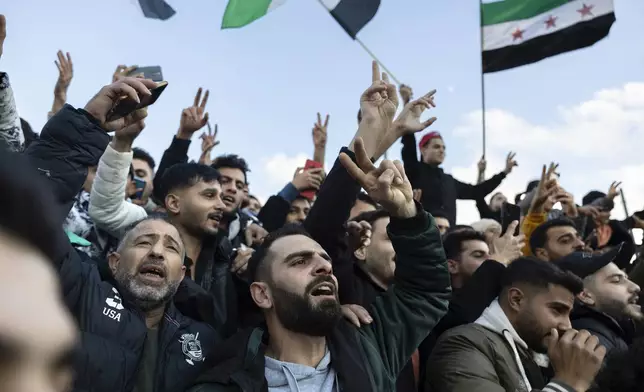 People attend a rally celebrating the fall of Syrian President Bashar Assad's government, at central Syntagma square, in Athens, Greece, Sunday, Dec. 8, 2024. (AP Photo/Yorgos Karahalis)