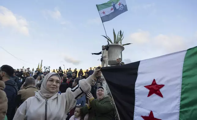 People attend a rally celebrating the fall of Syrian President Bashar Assad's government, at central Syntagma square, in Athens, Greece, Sunday, Dec. 8, 2024. (AP Photo/Yorgos Karahalis)