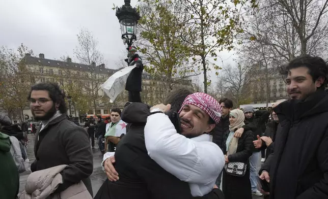 Syrians living in France hug during a rally on Republique square after the Syrian government fell early today in a stunning end to the 50-year rule of the Assad family, Sunday, Dec. 8, 2024 in Paris. (AP Photo/Aurelien Morissard)
