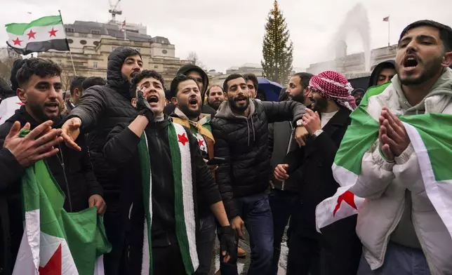 People gather to react following the fall of Syrian president Bashar Assad’s government, in Trafalgar Square, in London, Sunday, Dec. 8, 2024. (AP Photo/Alberto Pezzali)