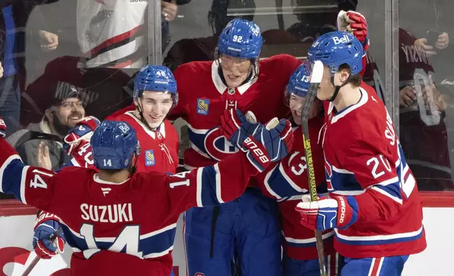 Montreal Canadiens' Patrik Laine (92) celebrates his first goal of the season with teammates Nick Suzuki (14), Lane Hutson (48), Cole Caufield (13) and Juraj Slafkovsky (20) during the second period of an NHL hockey game against the New York Islanders in Montreal, Tuesday, Dec. 3, 2024. (Christinne Muschi/The Canadian Press via AP)