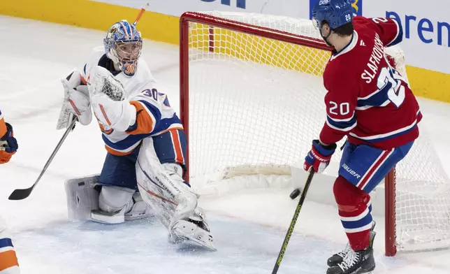 Montreal Canadiens' Juraj Slafkovsky (20) looks on as a shot by teammate Patrik Laine scores on New York Islanders goaltender Ilya Sorokin (30) during the second period of an NHL hockey game in Montreal, Tuesday, Dec. 3, 2024. (Christinne Muschi/The Canadian Press via AP)