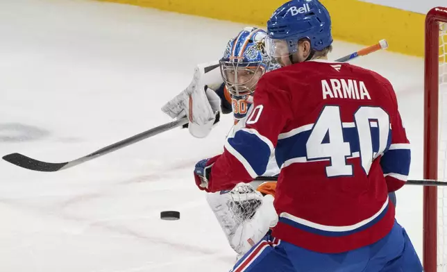 New York Islanders goaltender Ilya Sorokin, left, keeps an eye on the puck as Montreal Canadiens' Joel Armia (40) looks for the rebound during the second period of an NHL hockey game in Montreal, Tuesday, Dec. 3, 2024. (Christinne Muschi/The Canadian Press via AP)