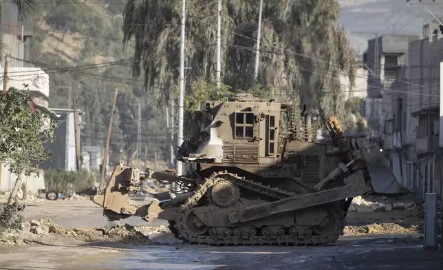 Israeli military bulldozers are seen during a military raid in the Nur Shams refugee camp near the West Bank city of Tulkarem, Tuesday, Dec. 24, 2024. (AP Photo/Majdi Mohammed)