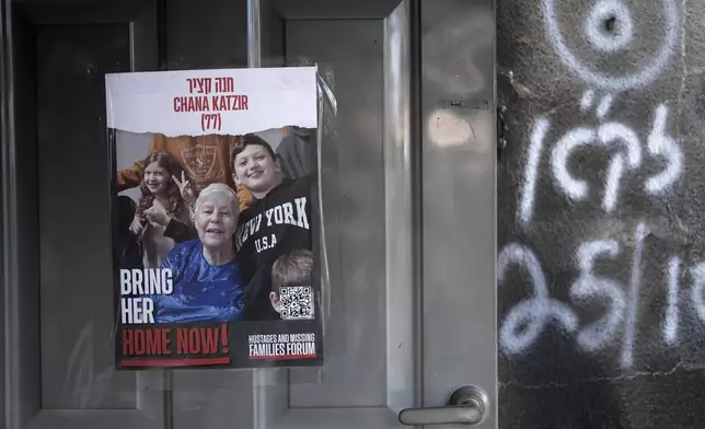 FILE - A poster calling for the release of Hannah (Chana) Katzir is taped to the door of her home in Kibbutz Nir Oz, on Nov. 21, 2023. (AP Photo/Maya Alleruzzo, File)