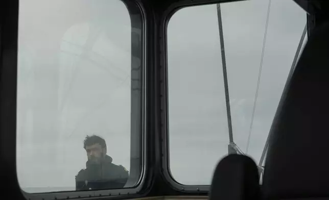 Captain of the Sailboat 'Grain de Sail II' Yann Jourdan stands on the deck as he sails off Saint Malo, western France, Nov. 6, 2024. (AP Photo/Thibault Camus)