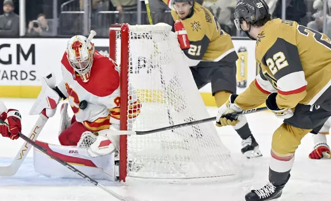 Calgary Flames goaltender Dan Vladar (80) blocks a shot by Vegas Golden Knights right wing Cole Schwindt (22) during the second period of an NHL hockey game Sunday, Dec. 29, 2024, in Las Vegas. (AP Photo/David Becker)