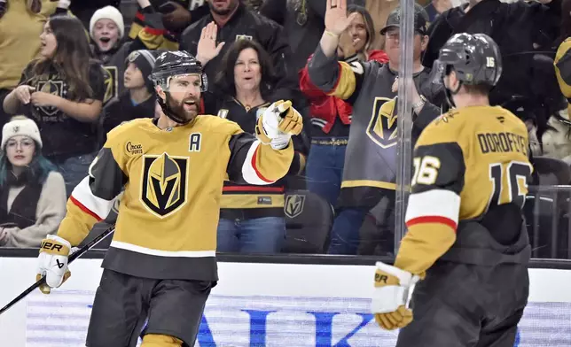 Vegas Golden Knights defenseman Alex Pietrangelo, left, reacts after scoring against the Calgary Flames during the second period of an NHL hockey game Sunday, Dec. 29, 2024, in Las Vegas. (AP Photo/David Becker)