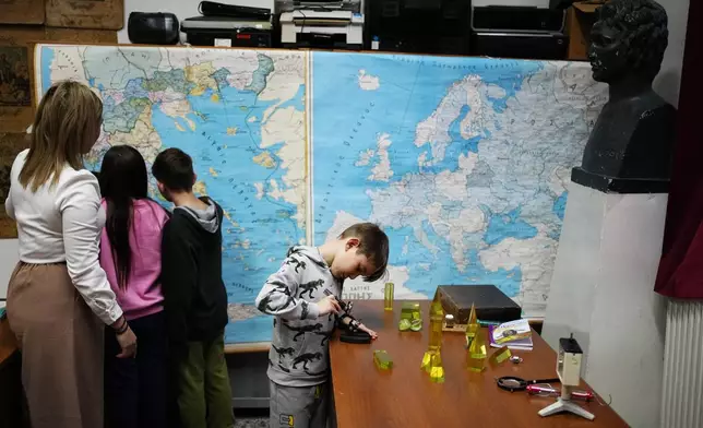 Students read maps with schoolteacher Panagiota Diamanti during class in Fourna village, central Greece, Monday, Nov. 25, 2024. (AP Photo/Thanassis Stavrakis)