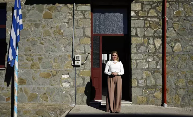 Schoolteacher Panagiota Diamanti poses for a portrait outside the primary school in Fourna village, central Greece, Monday, Nov. 25, 2024. (AP Photo/Thanassis Stavrakis)
